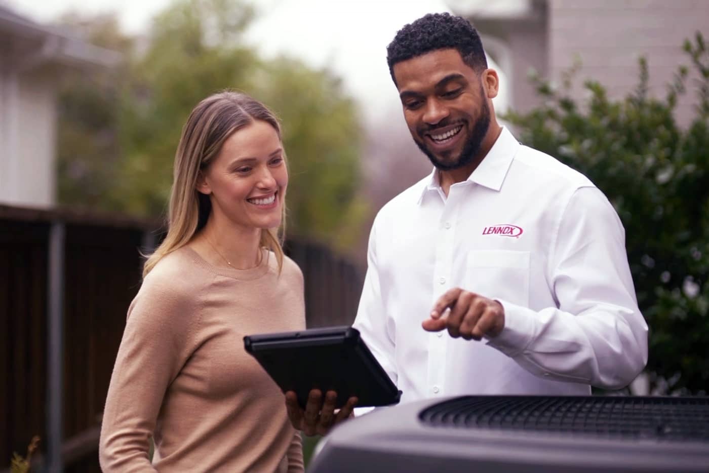 Technician and customer smiling outside