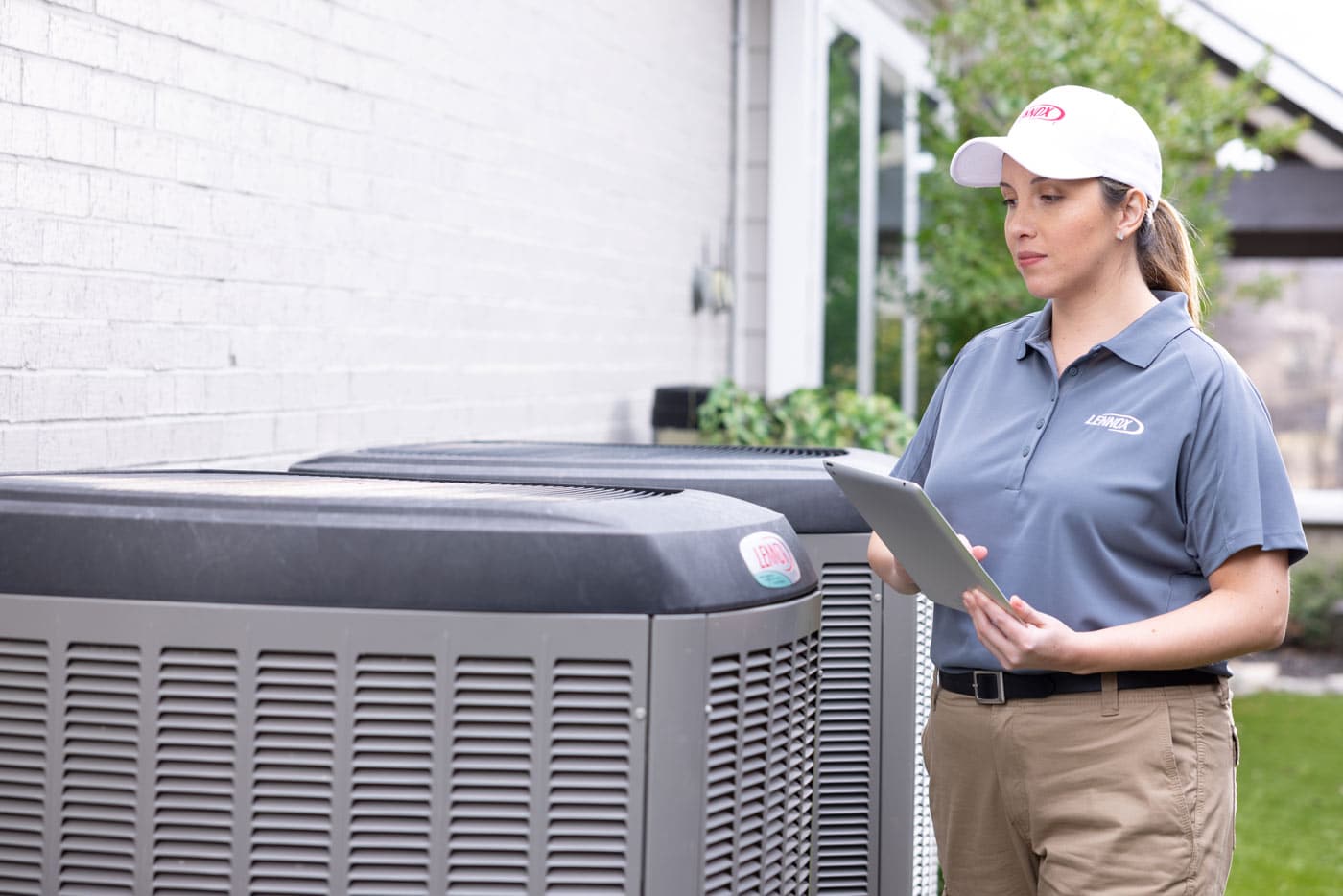 Woman technician checking heat pump outside