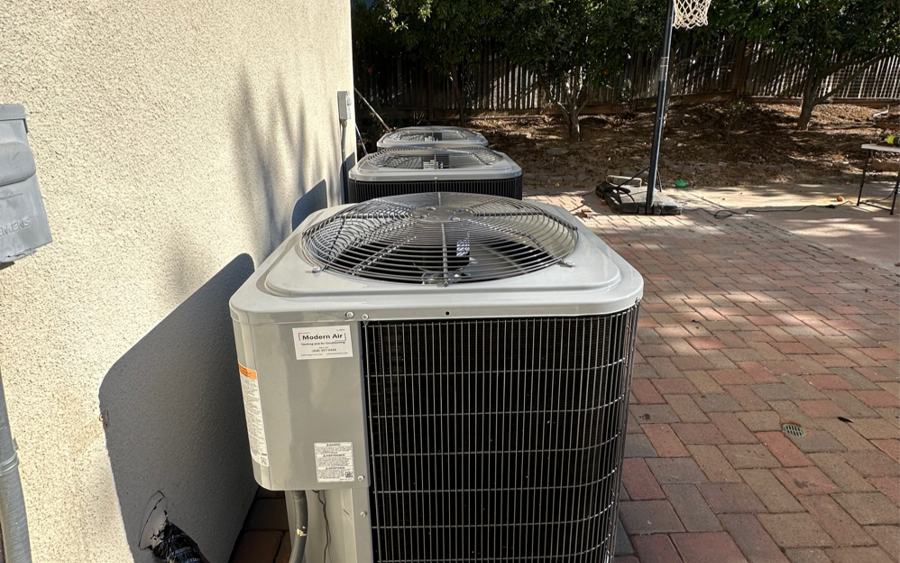 Air conditioner condenser installed on a brick patio at a South Bay home