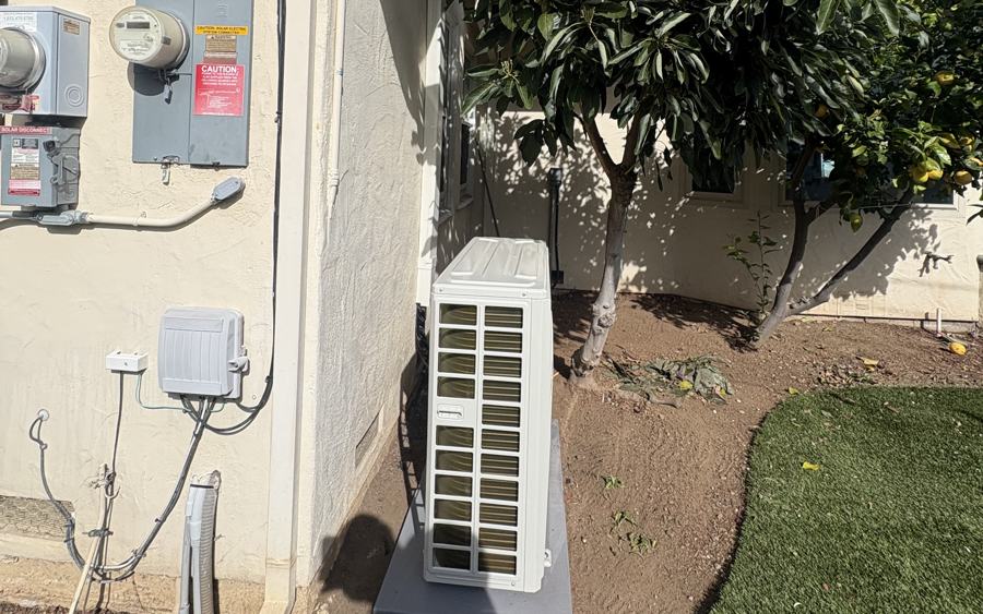 Ductless mini-split outdoor unit installed against a stucco wall