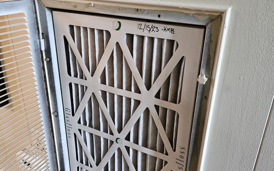 Fresh air filter installed behind a return grille, dated by the technician