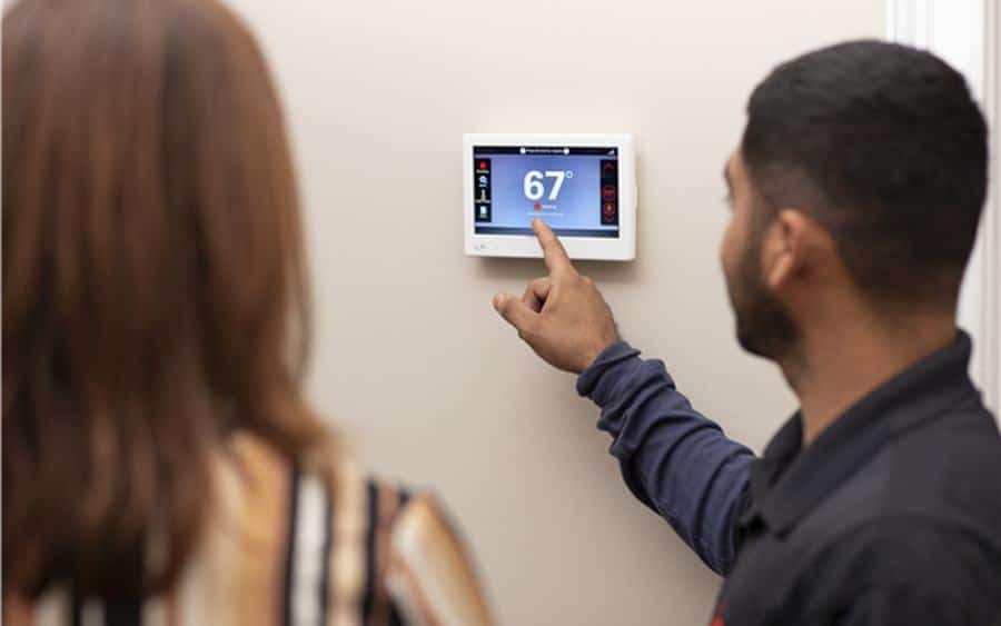 Modern Air technician helping a South Bay homeowner with indoor comfort controls