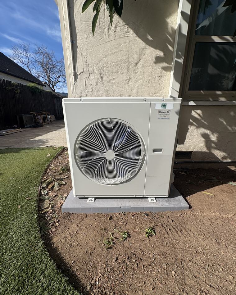 New inverter heat pump installed on a concrete pad by Modern Air