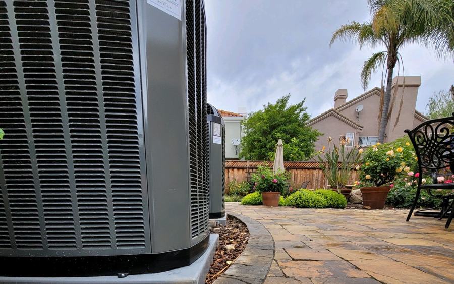 New Trane air conditioner condenser installed beside a landscaped backyard
