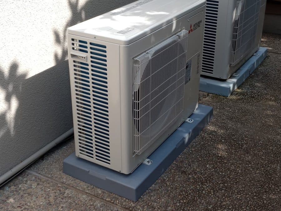 Two Mitsubishi Electric outdoor units on gray pads against a stucco wall, Los Altos, CA
